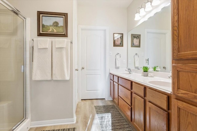 bathroom featuring vanity, wood-type flooring, and walk in shower