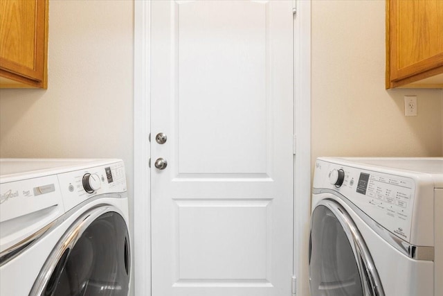 laundry room with cabinets and washer and clothes dryer