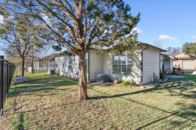 rear view of house featuring central AC and a lawn