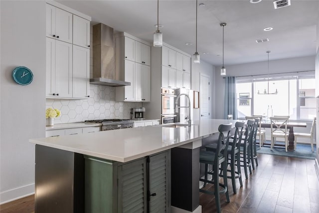 4007 Emory Peak Pass, Austin, TX 78731 - kitchen featuring wall chimney range hood, a large island, dark wood-type flooring, baseboards, and tasteful backsplash