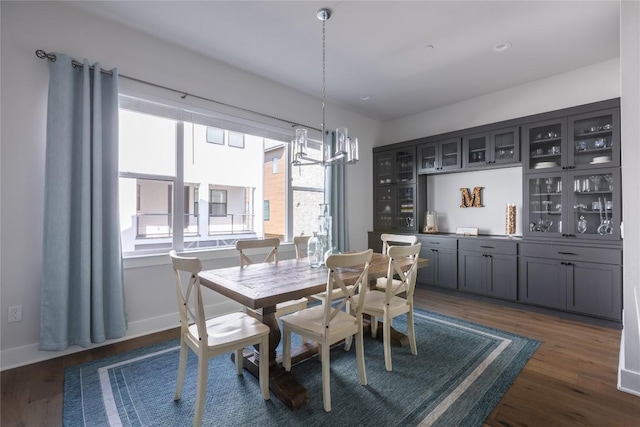 dining room with an inviting chandelier, baseboards, and dark wood finished floors