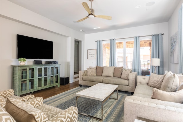 living room featuring ceiling fan and dark hardwood / wood-style floors