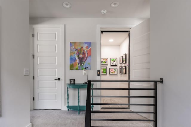 stairway with carpet floors and recessed lighting