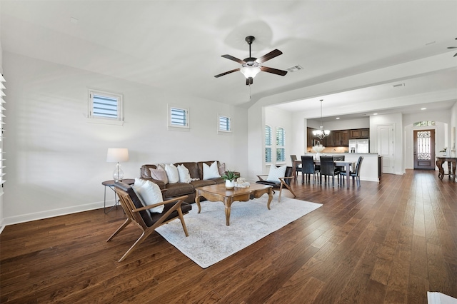 living room featuring ceiling fan with notable chandelier and dark hardwood / wood-style flooring