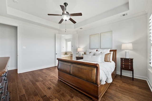 bedroom with ceiling fan, connected bathroom, and a tray ceiling