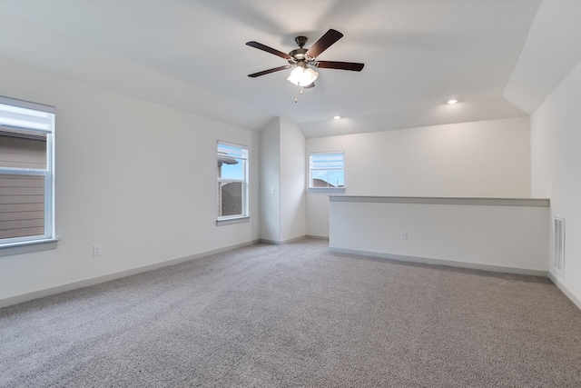 carpeted spare room with vaulted ceiling and ceiling fan