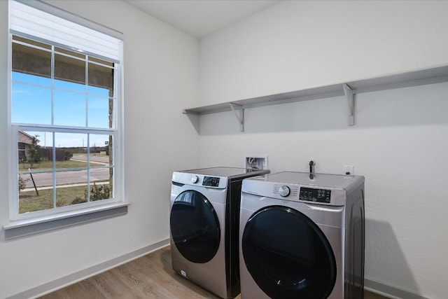 14117 Mcarthur Dr, Manor, TX 78653 - laundry room with washing machine and clothes dryer, wood finished floors, and baseboards