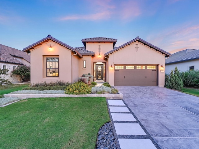 mediterranean / spanish-style home featuring a garage and a lawn