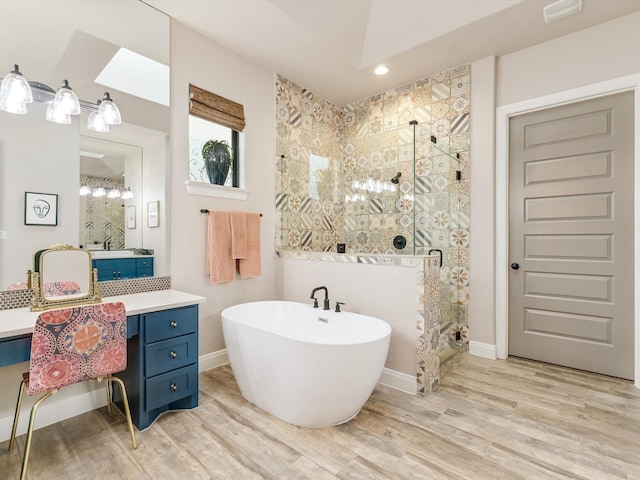 bathroom with wood-type flooring, plus walk in shower, and vanity