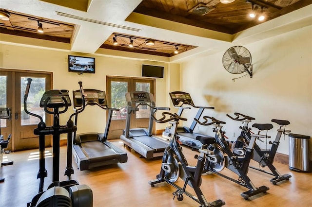 exercise room with hardwood / wood-style floors, a tray ceiling, wooden ceiling, and french doors