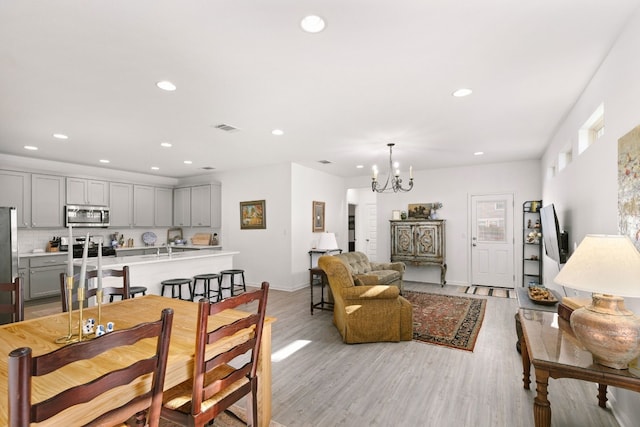 dining area with a chandelier, recessed lighting, visible vents, baseboards, and light wood finished floors