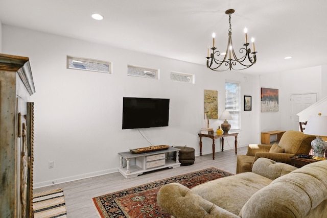 living room with light hardwood / wood-style floors and a notable chandelier