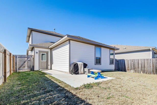 back of property with a patio area, a fenced backyard, and a lawn