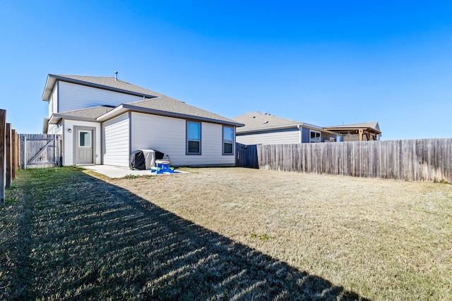 back of property with a yard and a fenced backyard