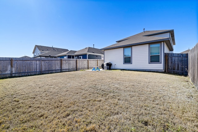 back of property featuring a fenced backyard and a yard