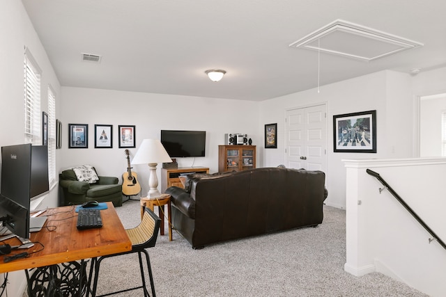 living area featuring attic access, visible vents, and light carpet