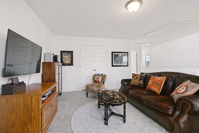 living area featuring carpet flooring and attic access