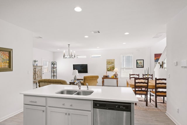 kitchen with visible vents, stainless steel dishwasher, light wood-style floors, open floor plan, and a sink