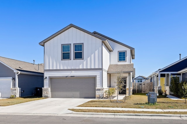 12403 Zenyatta Dr, Buda, TX 78610 - view of front of home with board and batten siding, concrete driveway, a garage, and stone siding