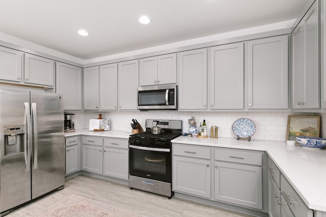12403 Zenyatta Dr, Buda, TX 78610 - kitchen featuring stainless steel appliances, gray cabinets, light countertops, decorative backsplash, and recessed lighting
