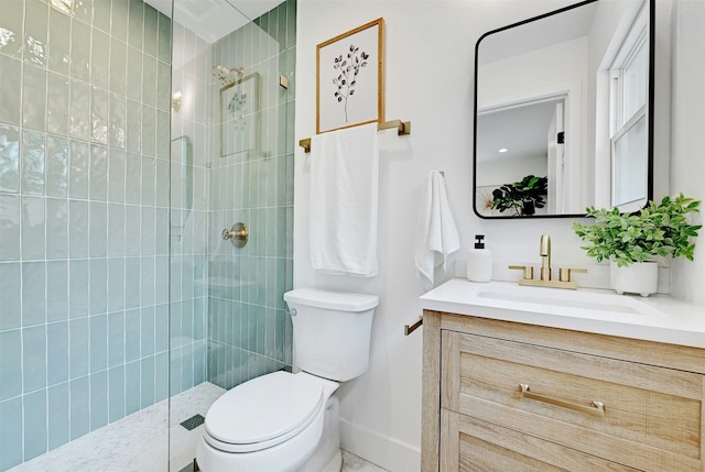 bathroom featuring toilet, vanity, and tiled shower