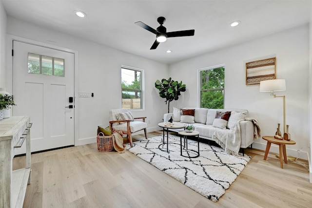 living room featuring ceiling fan and light hardwood / wood-style flooring