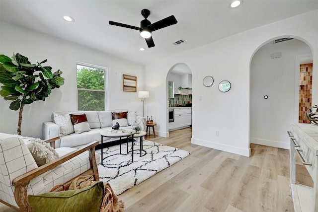 living room with light hardwood / wood-style floors and ceiling fan