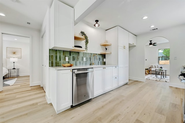 kitchen with stainless steel dishwasher, white cabinets, and backsplash