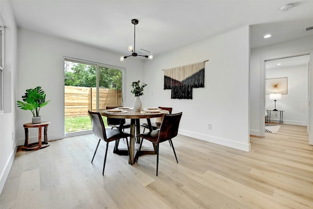 dining room featuring light wood-type flooring and an inviting chandelier