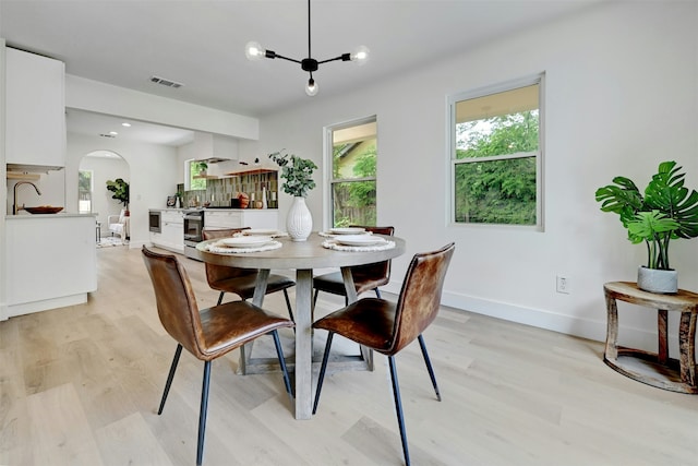 dining space featuring an inviting chandelier and light wood-type flooring