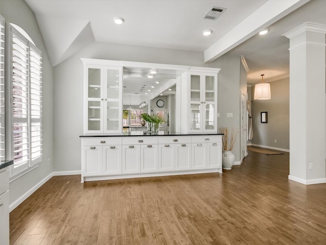 bar featuring decorative light fixtures, a healthy amount of sunlight, white cabinetry, and light hardwood / wood-style flooring