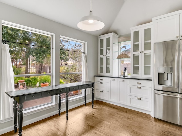 dining room with vaulted ceiling and light hardwood / wood-style floors