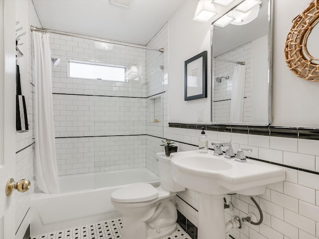 bathroom with toilet, tile walls, tile patterned floors, and shower / bath combination with curtain