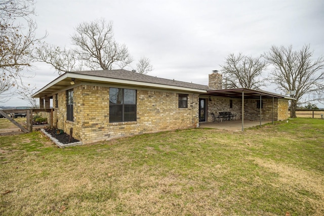 rear view of property with a yard and a patio