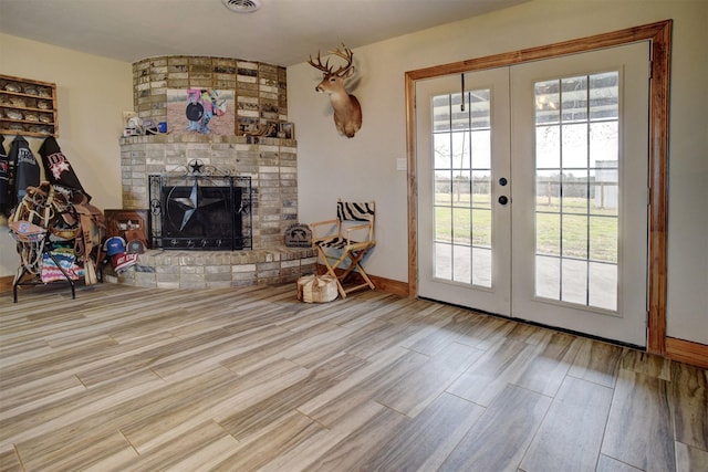 living room featuring french doors and a brick fireplace