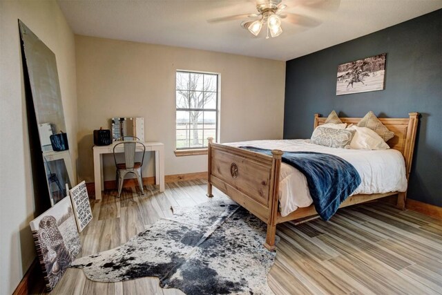 bedroom with ceiling fan and light hardwood / wood-style floors