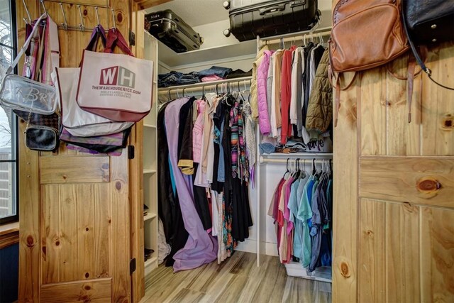 walk in closet with hardwood / wood-style floors