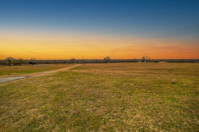 yard at dusk with a rural view