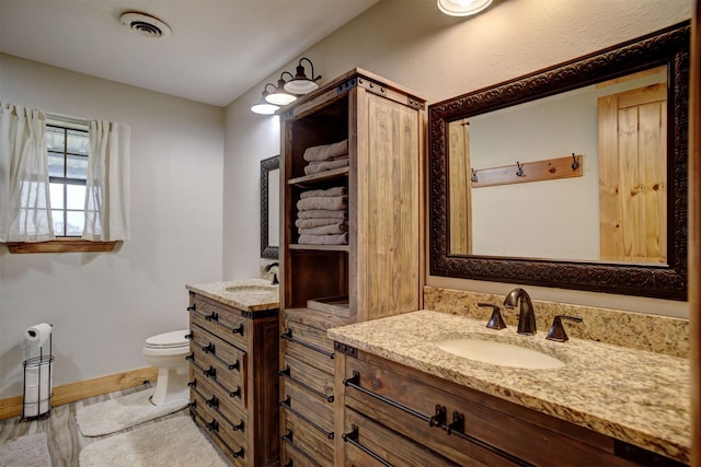 bathroom with toilet, vanity, and hardwood / wood-style flooring