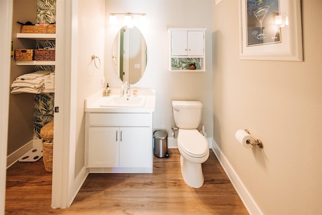 bathroom featuring toilet, vanity, and hardwood / wood-style floors