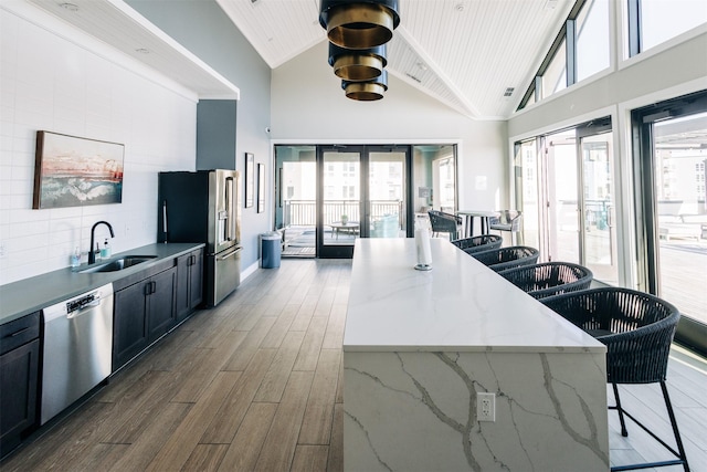 kitchen featuring light stone countertops, stainless steel appliances, french doors, sink, and wooden ceiling