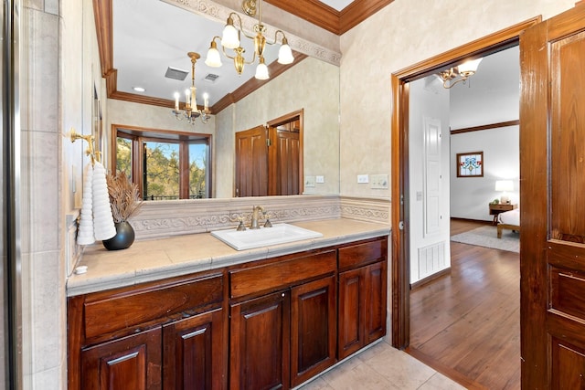 bathroom with crown molding, vanity, tile patterned floors, and an inviting chandelier