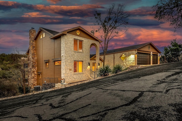 view of front of house with a garage and central AC