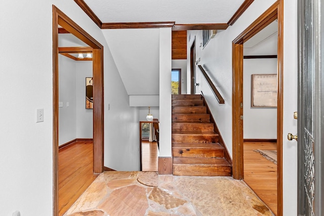 stairs featuring ornamental molding and hardwood / wood-style flooring