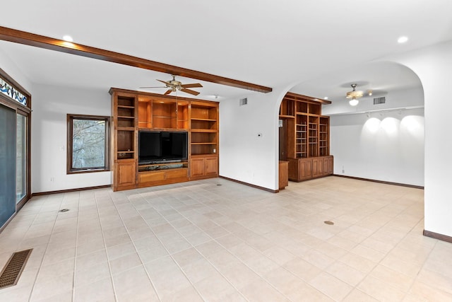 unfurnished living room featuring ceiling fan and beamed ceiling