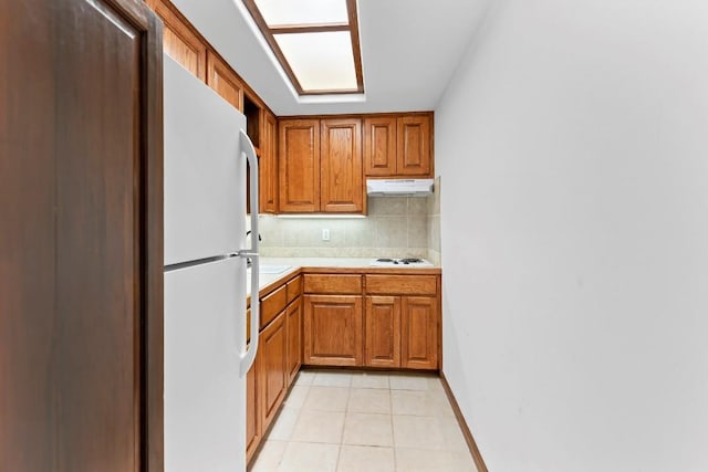 112 Center Cove Iii Loop, Spicewood, TX 78669 - kitchen featuring white appliances, light countertops, under cabinet range hood, tasteful backsplash, and brown cabinetry