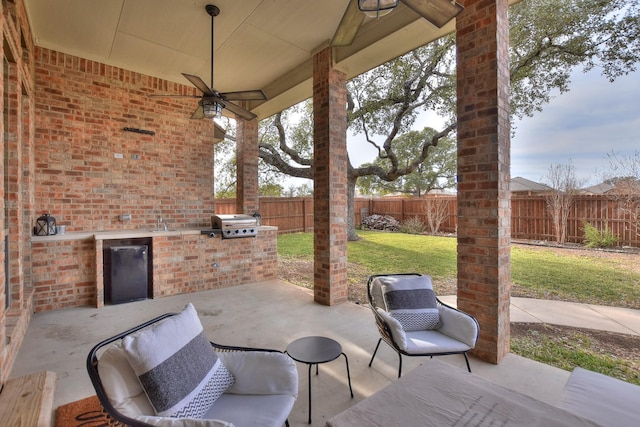 view of patio with sink, an outdoor kitchen, a grill, and ceiling fan