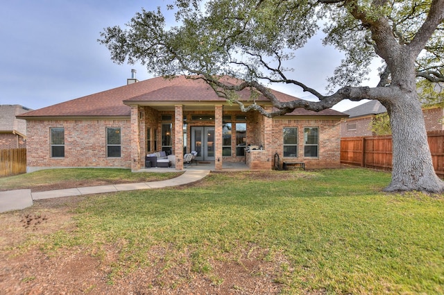 rear view of house with a patio area and a lawn