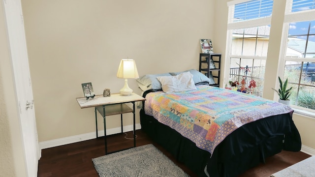 bedroom with baseboards and wood finished floors