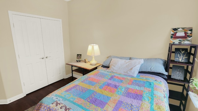 bedroom with a closet, baseboards, and wood finished floors